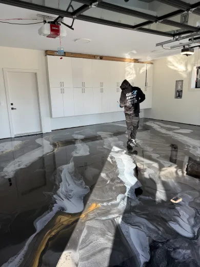 Go2Epoxy installer in company uniform inspecting a newly installed metallic epoxy garage floor